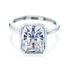 a white gold ring with a square cut diamond in the center and a thin band around it