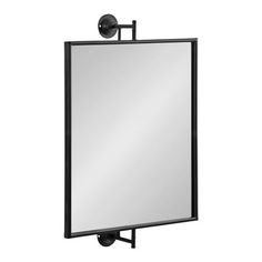 a large mirror mounted on the wall with a black metal frame and an adjustable arm