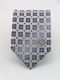 "This silk necktie make a stunning Christmas gift for anyone. Also makes a great wedding necktie. Features a silver background with a gray geometric pattern. Also available as a extra long Necktie. Handmade from 100% silk, this special collection features a .75\" Eds Neckties logo at the bottom right front corner of every tie and a larger logo located on the tipping (Back of the tie). The label features the collection name (Nathaniel Alexandria) Named after my son Nathaniel and my daughter Alexa Silver Standard Tie For Black Tie Events, Gray Suit And Tie Accessories For Black Tie Event, Elegant Gray Business Tie, Silver Ties For Black Tie Events, Elegant Silver Ties For Office, Elegant Silver Tie As A Gift, Elegant Silver Office Tie, Elegant Silver Office Ties, Silver Tie As A Gift