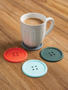 three different colored buttons next to a cup of coffee