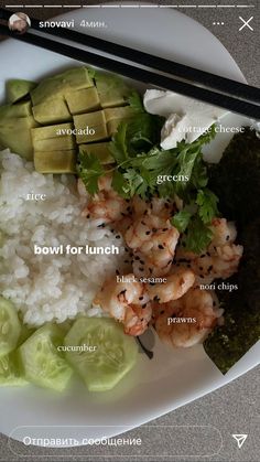 a white plate topped with rice, cucumber and shrimp next to chopsticks