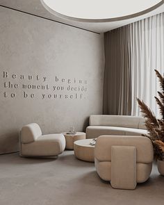 a living room filled with furniture and a quote on the wall next to a potted plant