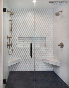 a bathroom with a walk in shower next to a tiled wall