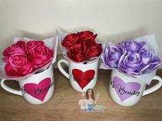 three coffee mugs with roses in them on a table