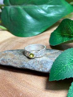 A handcrafted Silver ring adorning a beautiful peridot gemstone!  This is crafted with metal clay, a medium that when heated turns to 999 solid silver! Natural oxidation can occur Ring is a size 5 Peridot is a powerful cleanser.  It releases and neutralises toxins on all levels.  Alleviates jealousy, resentment, spite, bitterness, irritation, hatred and greed.  Reduces stress, anger and guilt.  Peridot opens our hearts to joy and new relationships.  It enhances confidence and assertion, motivati Nature-inspired Sapphire Ring For Anniversary, Green Citrine Round Jewelry, Oval Citrine Green Jewelry, Oval Green Citrine Jewelry, Green Round Citrine Jewelry, Unique Green Sapphire Ring With Accent Stones, Citrine Gemstone Jewelry For May Birthstone, Peridot Gemstone Crystal Ring For Anniversary, Green Sterling Silver Topaz Ring