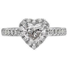 A beautiful engagement ring, featuring a 1.07 carats heart shape diamond certified by GIA as D color and SI1 clarity, set on a three prong setting. Surrounded by a halo of round brilliant cut diamonds and accented with a diamond encrusted shank in a half infinity setting. Accent diamonds weigh 0.34 carat total. Made with an 18K white gold mounting, 9.6 mm in length and 9.4 mm in width. Size 6.75 US, resizable upon request. Roman Malakov is a custom house, specializing in creating anything you ca Gia Certified Heart Cut Diamond Ring, Moissanite Heart Cut Diamond Ring For Proposal, Gia Certified Heart Shaped Anniversary Ring, Gia Certified Heart-shaped Ring For Anniversary, Heart Cut Moissanite Diamond Ring For Proposal, Heart-shaped Gia Certified Ring For Anniversary, Gia Certified Heart Shaped Fine Jewelry Ring, Gia Certified Heart Diamond Rings, Heart Cut Brilliant Diamond Proposal Ring