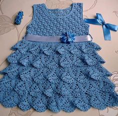 a blue crocheted dress with a bow on it