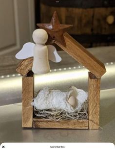 a small wooden nativity scene with a star on the top and sheep in it