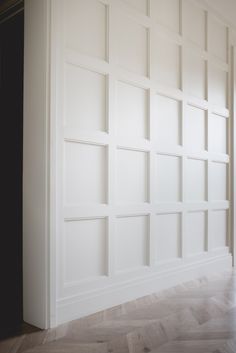 an empty room with white walls and wood flooring on the wall is seen in this image