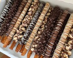 there are many different kinds of donuts in the box on this table, including one with chocolate and peanut butter