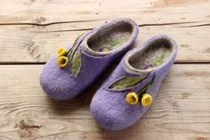 a pair of purple slippers with yellow flowers on them sitting on a wooden surface