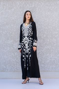 This beautiful Kaftan with the Siwa inspired embroidery is a bohemian and flashy dress that will catch everyone's eyes. it is a show stopper. This Kaftan is ideal to wear for any casual occasion. Whether taking a trip down the shopping lane, or home-based kitty parties, or about anything else, wearing this dress will make you feel classy and comfortable. Fabric : 70% Egyptian Cotton 30% Polyester  Kaftan measurements in inches : Small (Size 4/6 USA) Bust : 36-37   Hip : 40-41   Medium (Size 8/10 Black Thobe With Floral Embroidery And Long Sleeves, Black Long Sleeve Thobe With Floral Embroidery, Black Long Sleeve Festival Kaftan, Black Kaftan For Eid, Bohemian Black Kaftan For Eid, Black Bohemian Kaftan For Eid, Traditional Long Black Kaftan, Black Tunic Kaftan For Festival, Black Festival Tunic Kaftan