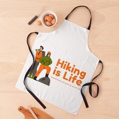 an apron with the words hiking is life on it next to eggs and utensils