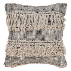 a gray and white pillow with fringes on it