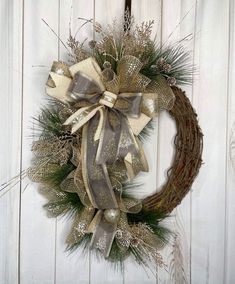 a christmas wreath hanging on the side of a white wooden door with silver and gold decorations