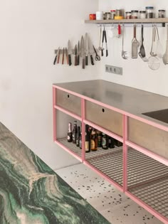 a kitchen counter with utensils hanging on the wall