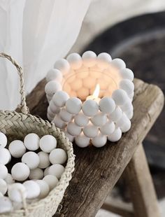 a basket filled with marshmallows next to a lit candle