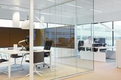 an office with glass walls and desks