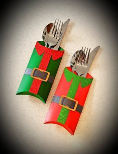 two forks and knife holders made out of toilet paper wrapped in christmas colors with silverware