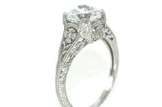 an antique style diamond engagement ring with filigrees