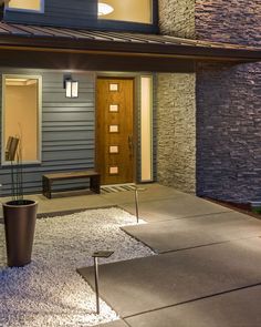 the front door of a modern home lit up at night