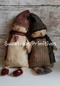 two stuffed snowmen sitting next to each other on top of a white surface with the words sweet peas primitives