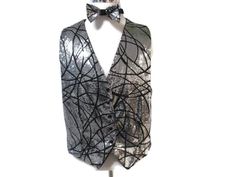 "Silver and Black Sequence Vest with Bowtie.  The background is black with silver sewn on sequence.  This vest can be worn by a man or woman.  It also can be dressed down by pairing with a pair of jeans.  It has 5 snap closures in the front and is fully lined with black cotton fabric.  The bottom of the vest comes to two points.  The measurements are chest-44\", base of neck to bottom 22\", base of neck to front points 24\".  Perfect for the Holidays.  A must have for your wardrobe."