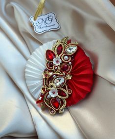 Red and white Shibori and soutache Brooch for women. The material used:  - Silk Shibori ribbon  - Soutache cord - Colorful glass crystal - Austrian crystals loose beads - Bicone crystal beads - Rhinestone cup chain  - Czech beads - backside: leather, edges embroidered with beading techniques  Approx. length: 9 cm (3.54 inch) Approx. width: 9 cm (3.54 inch) Used Techniques: Soutache embroidery, Shibori techniques, Beading.  This Brooch is handmade and most of the details are hand sewn with a strong colorless fly line.     Brooches are made to order. Please be aware, that due to the fact that I don't make copies of the jewelry, each piece of them has got a tiny distinguished detail so as to be unique and personalized, though colors and general design can remain. Each piece of jewelry is pack Shibori Ribbon Jewelry, Shibori Ribbon, Shibori Jewelry, Poppy Brooches, Rhinestone Cups, Shibori Techniques, Shibori Silk, Unique Brooch, Beading Techniques