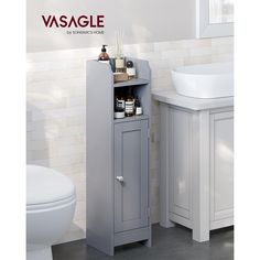 a white toilet sitting next to a gray cabinet