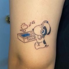 a cartoon dog with headphones playing the electronic music on his foot tattoo by an unknown person