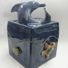 a ceramic container with a dolphin on it