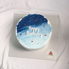 a birthday cake with blue frosting and hearts on the top that says happy birthday