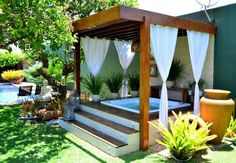 an outdoor hot tub in the middle of a yard with trees and plants around it