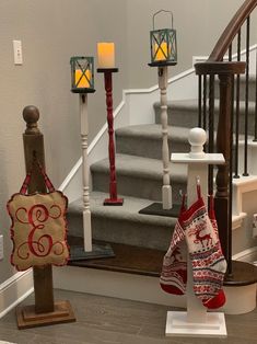 christmas stockings and candles are on display in front of the banisters at the bottom of the stairs