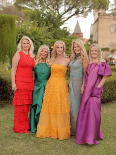 four women in dresses posing for the camera