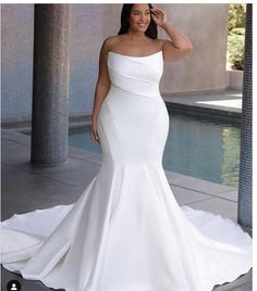 a woman in a white wedding dress standing next to a pool