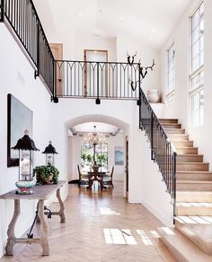 an entry way with stairs and tables in it