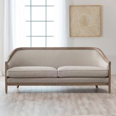 a beige couch sitting in front of a window