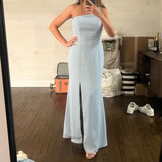 a woman taking a selfie in front of a mirror wearing a long blue dress