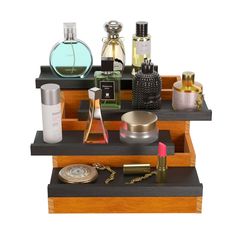 three wooden trays with different types of cosmetics and perfume bottles on top of each other