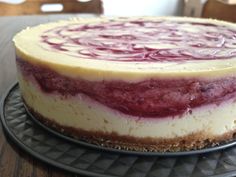 a cheesecake is sitting on a black plate