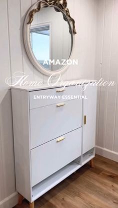 a white dresser sitting next to a mirror on top of a wooden floor