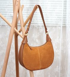 Ce sac à bandoulière fourre-tout en cuir véritable pour femme, élégant et spacieux, est parfait pour le travail, les voyages ou un usage quotidien. Fabriqué en cuir de haute qualité, ce sac à main tendance dispose d'un compartiment principal spacieux, d'une bandoulière réglable et de plusieurs poches intérieures et extérieures pour l'organisation. Idéal pour transporter vos essentiels dans un style intemporel.

 MATÉRIEL - Fabriqué à 100% en croûte de cuir de vachette de haute qualité et en cuir Daily Use Shoulder Bag With Metal Hardware, Daily Shoulder Bag With Metal Hardware And Round Handle, Brown Suede Bag With Gold-tone Hardware, Elegant Brown Hobo Bag With Suede Lining, Brown Suede Top Handle Hobo Bag, Leather Shoulder Bag With Suede Lining, Elegant Brown Shoulder Bag With Suede Lining, Modern Brown Shoulder Bag With Brass Hardware, Leather Shoulder Bag With Suede Lining For Everyday