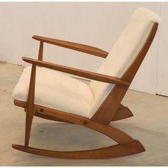 a wooden rocking chair with a white cushion