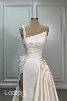 a white wedding dress on display in front of a mannequin headdress