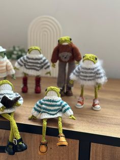 several knitted dolls are lined up on a table with one doll in the middle