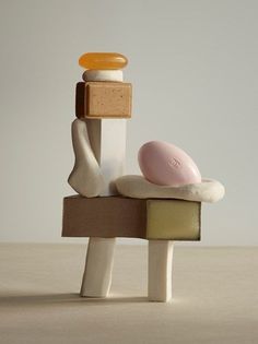 a small toy sitting on top of a pile of different colored blocks and pieces of wood