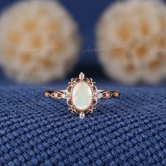 an opalite and diamond ring sitting on top of a blue blanket