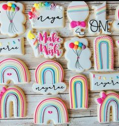 decorated cookies with rainbows, clouds and balloons are displayed on a wooden table top