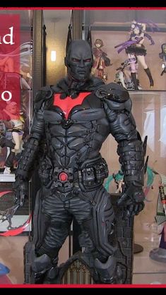 a display case with batman action figures on it's sides and an advertisement in the background